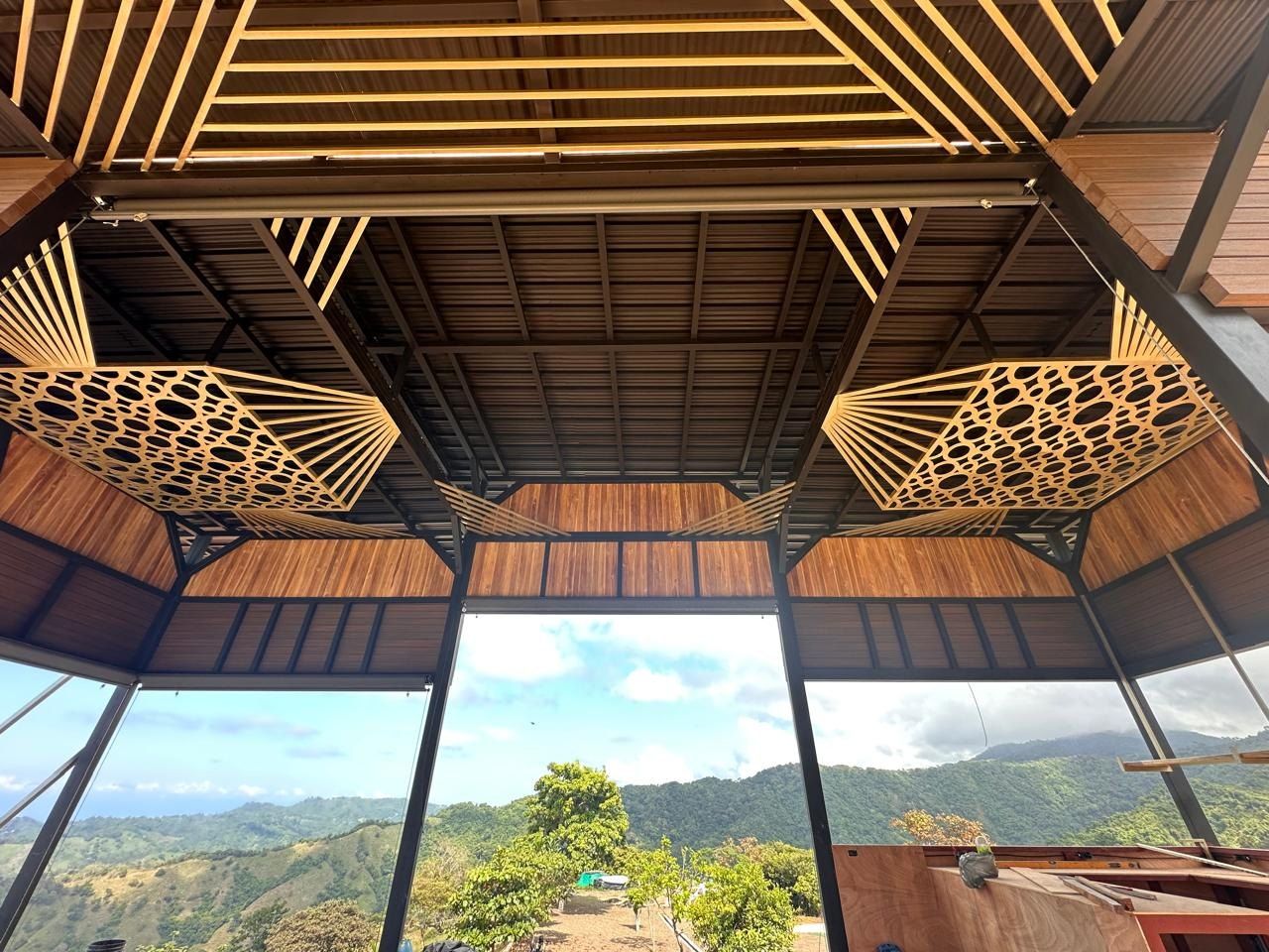 Pabellón mirador con cielos de celosía en madera frente a las montañas, construido por Grupo Trejos